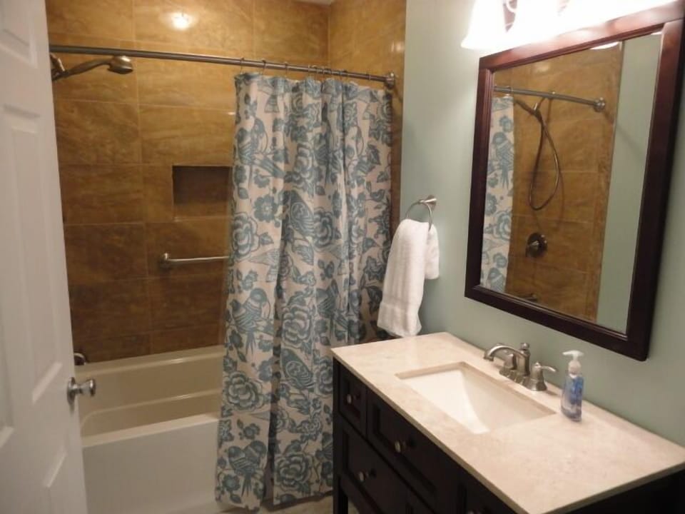 Guest Bathroom with tub / shower combination w/ porcelain tile surround