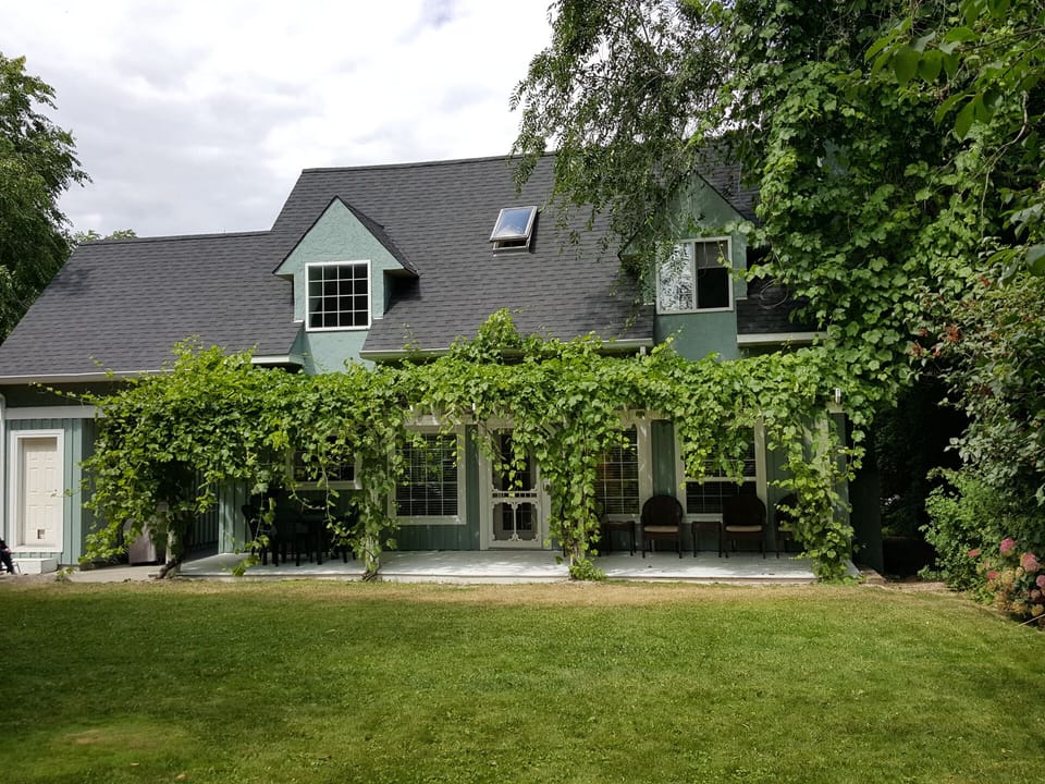Rear (South) Elevation. Spacious, flat backyard opens off the shaded porch.