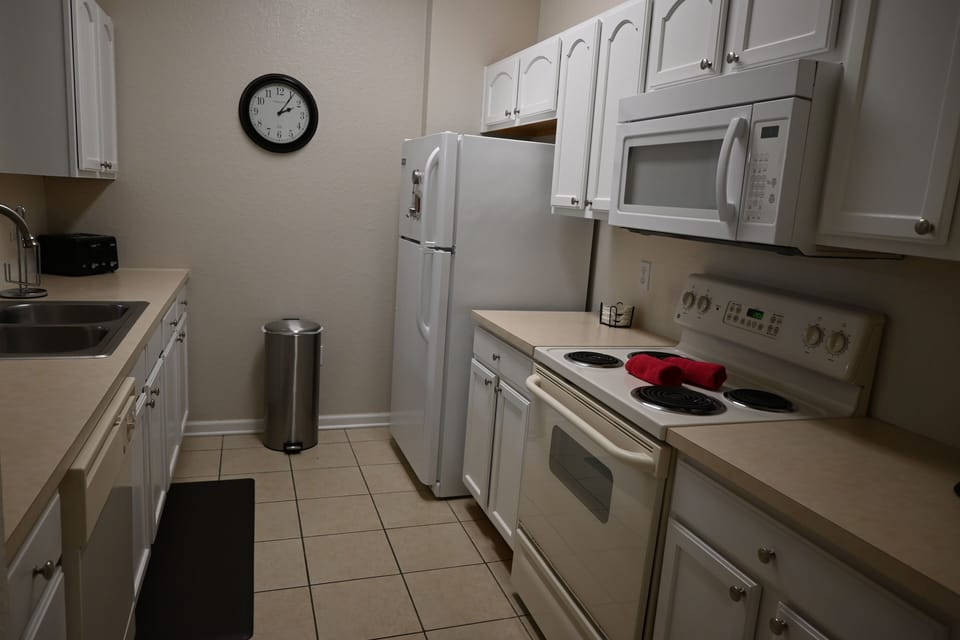 Galley kitchen with microwave, stove top, and oven.