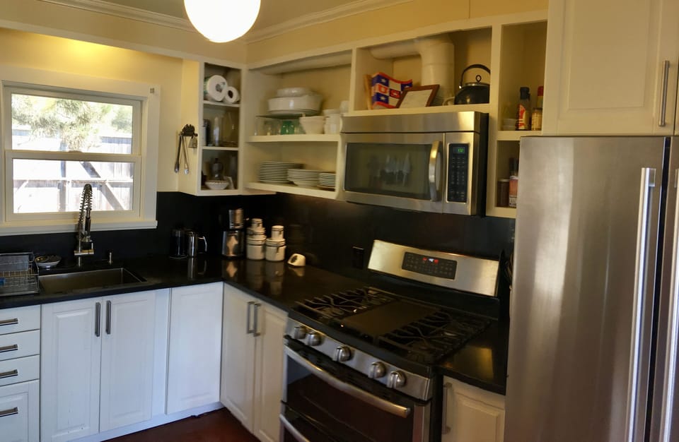 Full kitchen with dishwasher, cookware, tableware and washer/dryer.