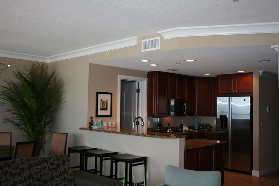 Chef's kitchen fully equipped for a feast and seating at the bar.