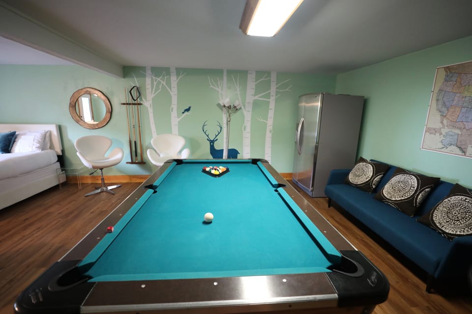 Pool table, ping pong table, TV, and refrigerator.