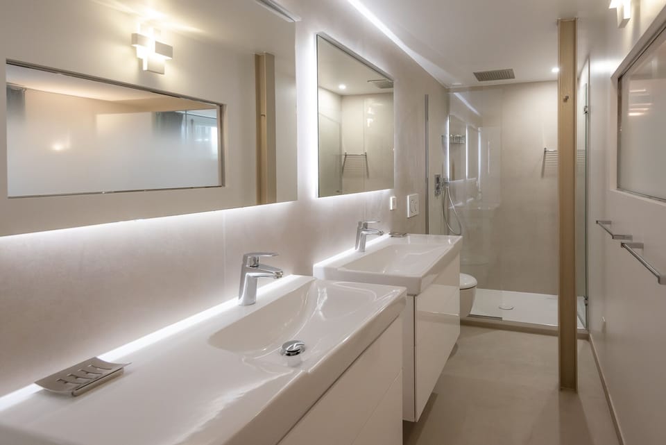 Bathroom 1 offers 2 vanity areas, a walk in shower and a toilet