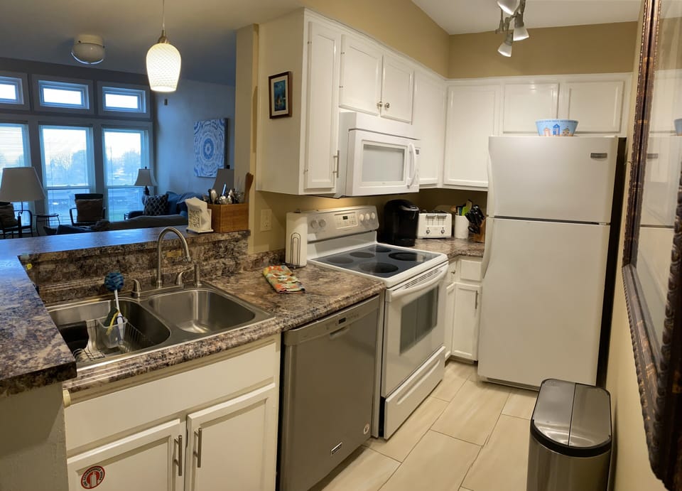 Galley kitchen with updated appliances and a view of the lake. 