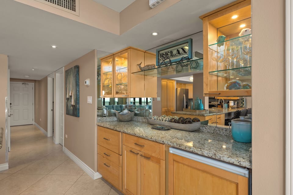 Hallway facing front door with bar and fridge