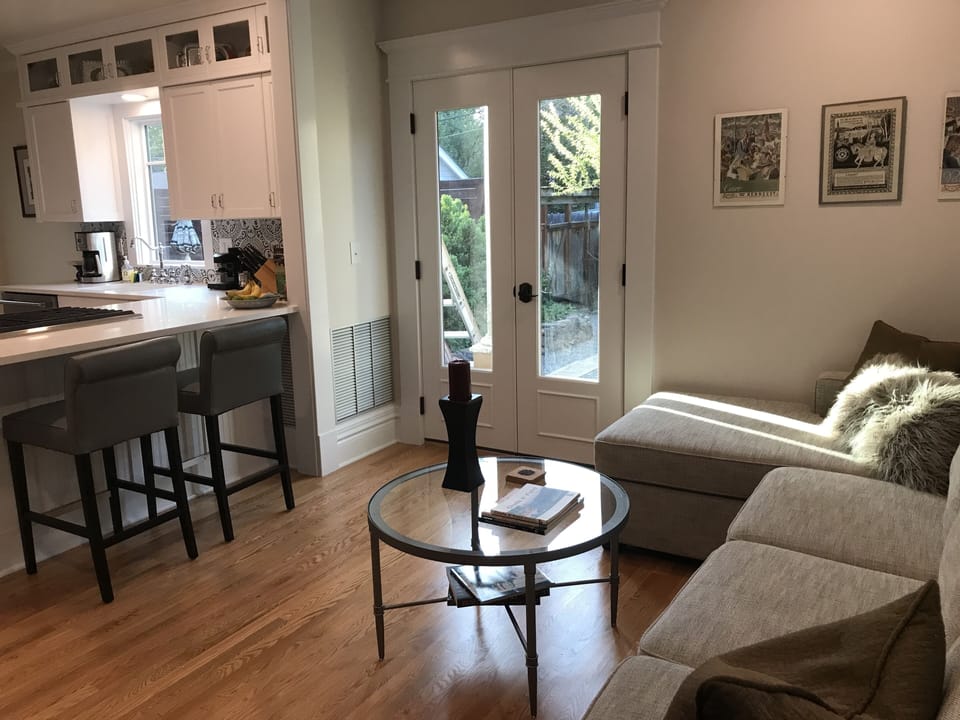Kitchen den area opens to back yard. Sleeper sofa, tv, sound system.