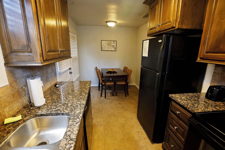 Kitchen view into cozy dining area with seating for four guests.