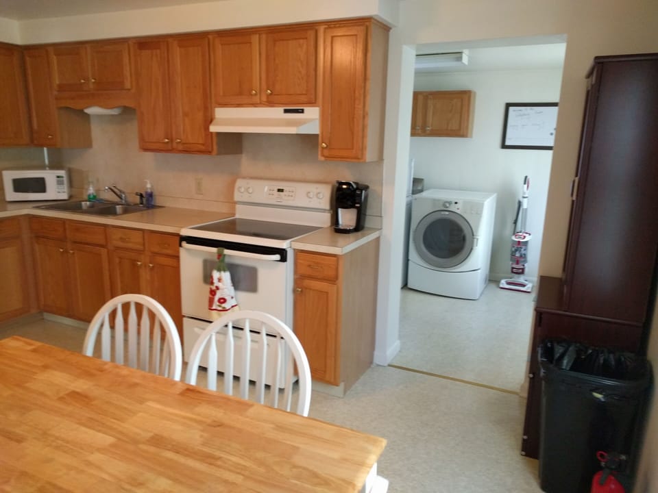 Microwave, Kuerig, coffee, pots, pans, dishes, paper towels and supplies.
