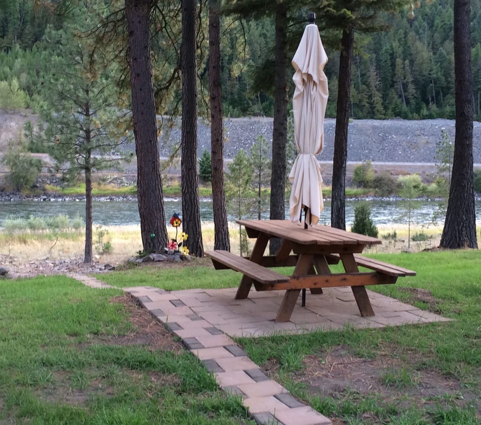 Picnic table on lawn overlooking river.  Pathway to river.