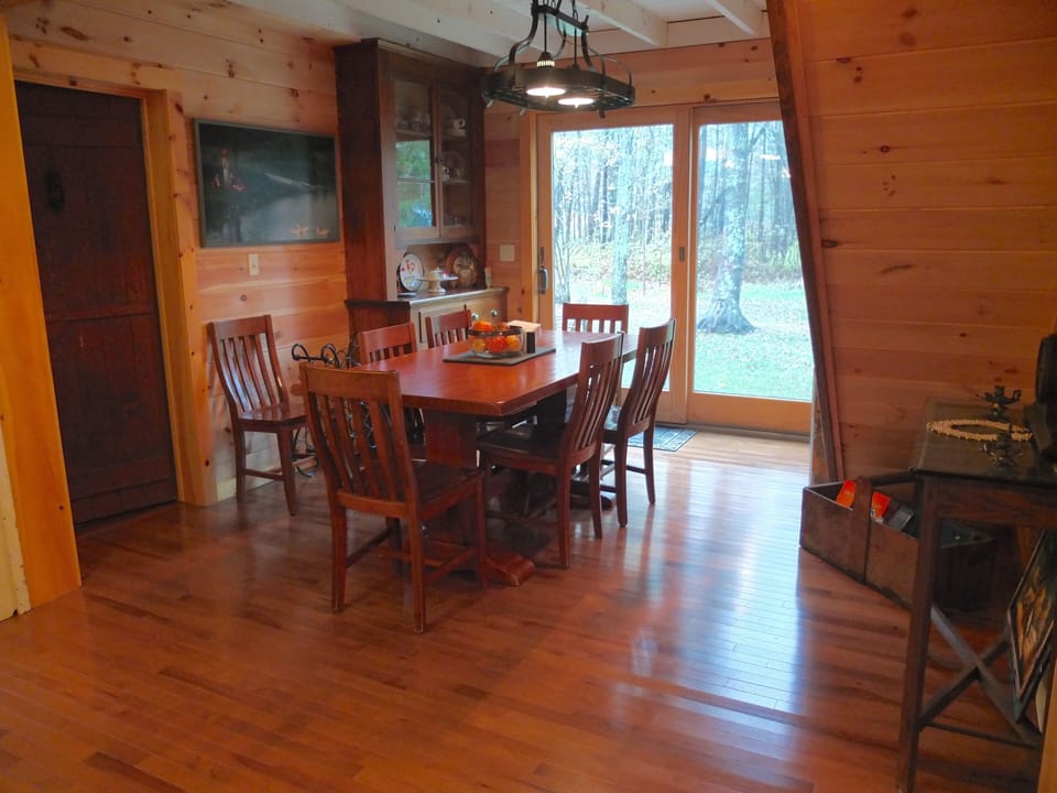 View of main dining area from dining nook & antique barn door to downstairs bath
