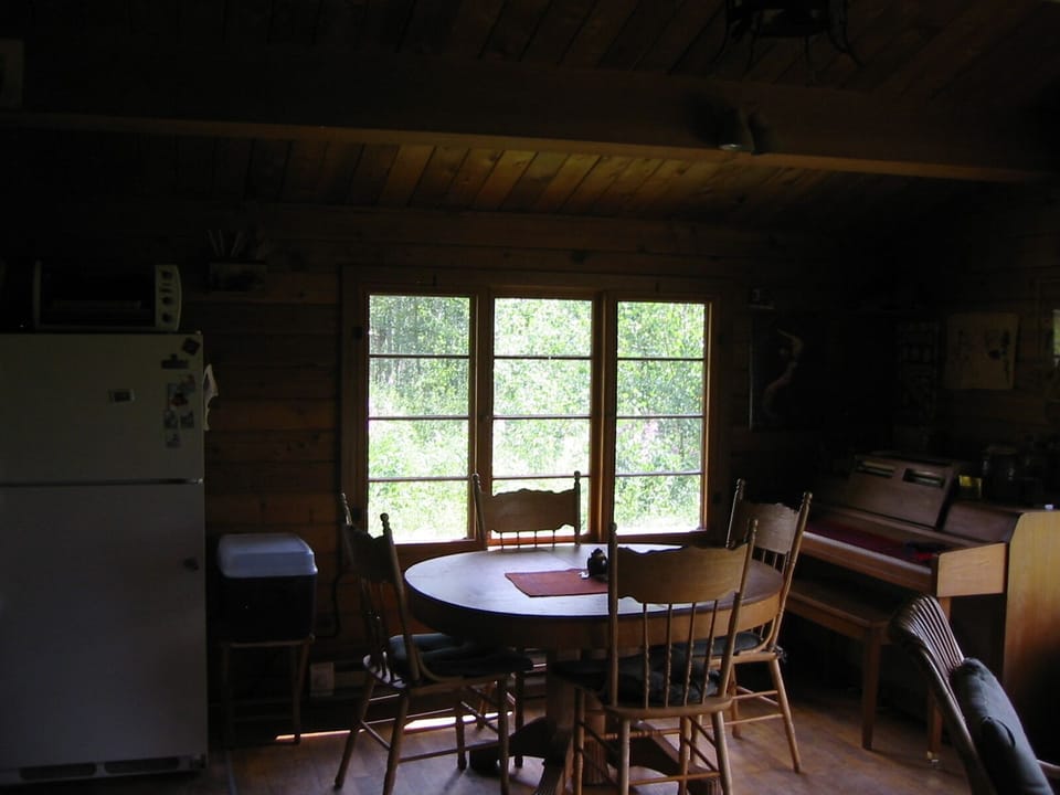 Dining area and piano, also in the living room. Table opens to seat six.