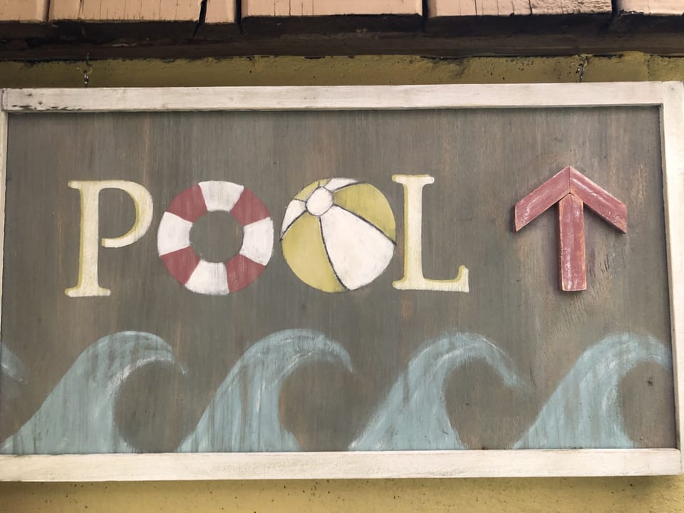 Spiral staircase outside kitchen door leads up to pool and deck.