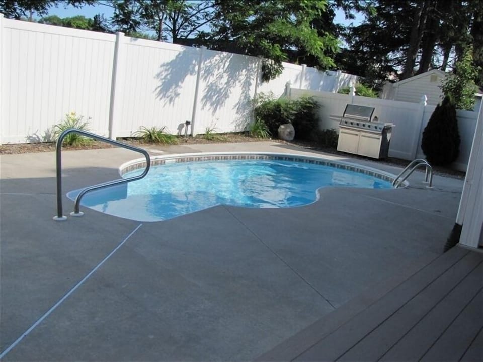Fenced in yard with private inground pool, BBQ and outdoor seating.