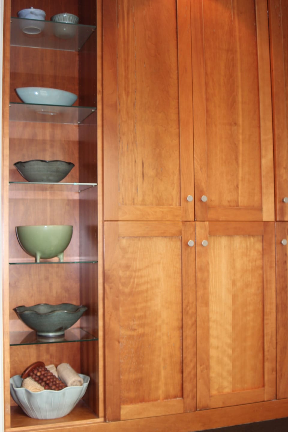Custom cherry wood cabinetry and fine decorative ceramics in primary bathroom