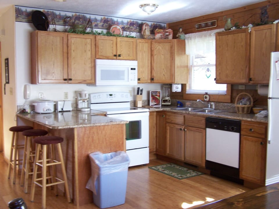 Kitchen with granite counter tops, glass top stove, microwave, and appliances
