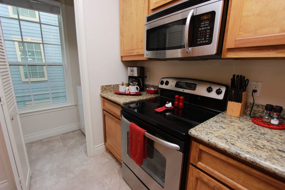 Kitchen with glass top electric range and oven and microwave. 