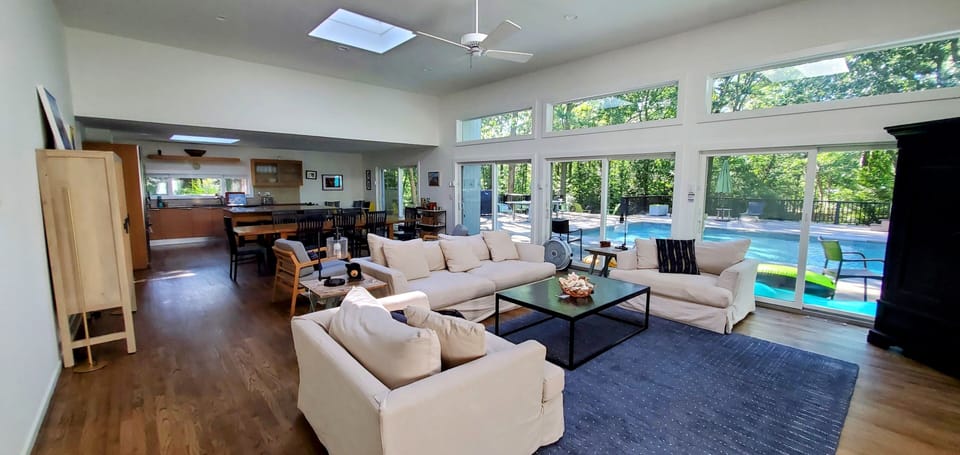 Newly renovated, open concept living and dining room with views of the pool. 