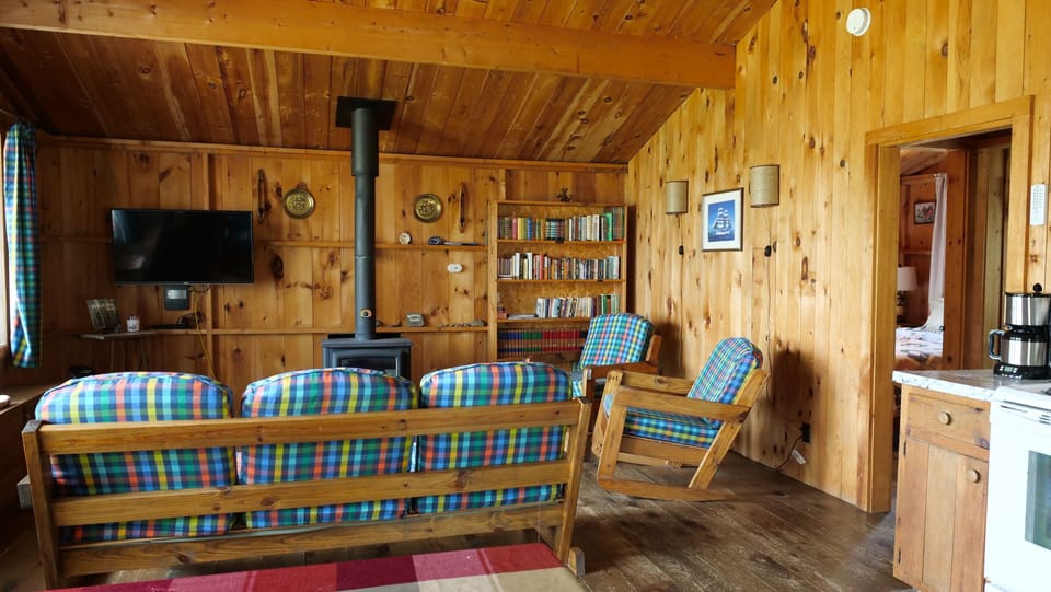 Living room with comfortable couch and chairs. Bookcase of books and board games