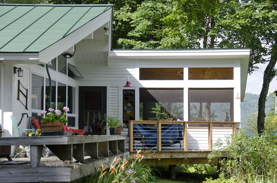 A deck with a view, gas grill and firepit overlooking gardens and the Green Mtns