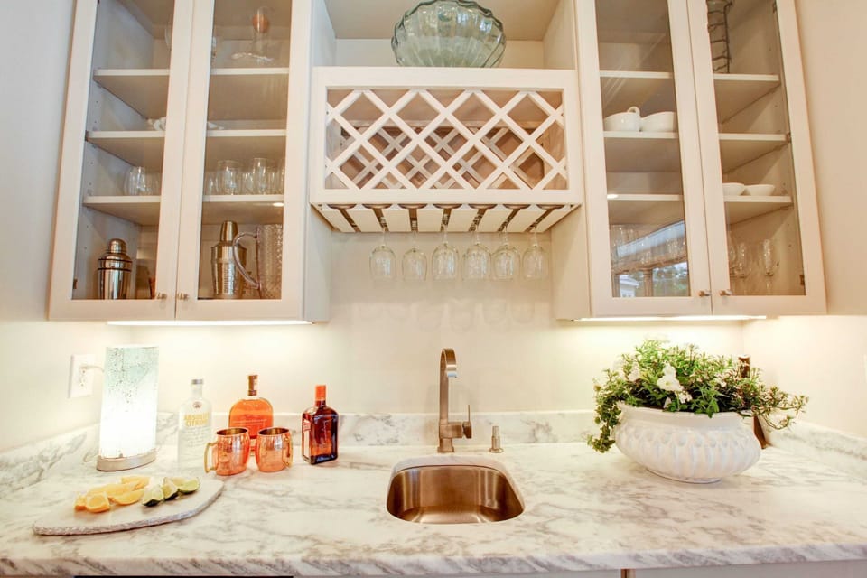 Wet bar is fully stocked with wine glasses and bar tools for a nice cocktail.