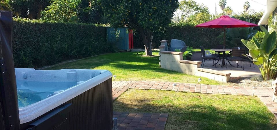 Backyard where you enjoy the hot tub, grilling, and the oranges from our tree.