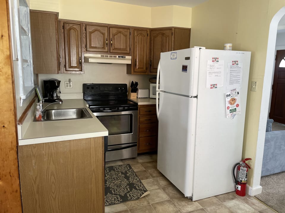Fully equipped kitchen with small dishwasher, microwave, stove, coffee pot. 