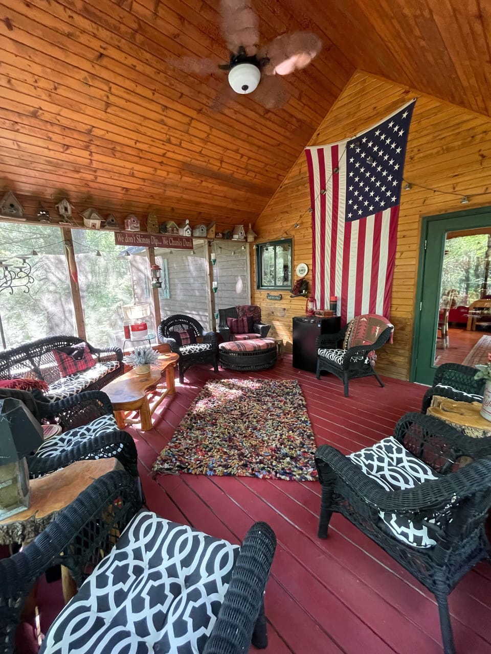 Screen porch overlooks lake with drink fridge