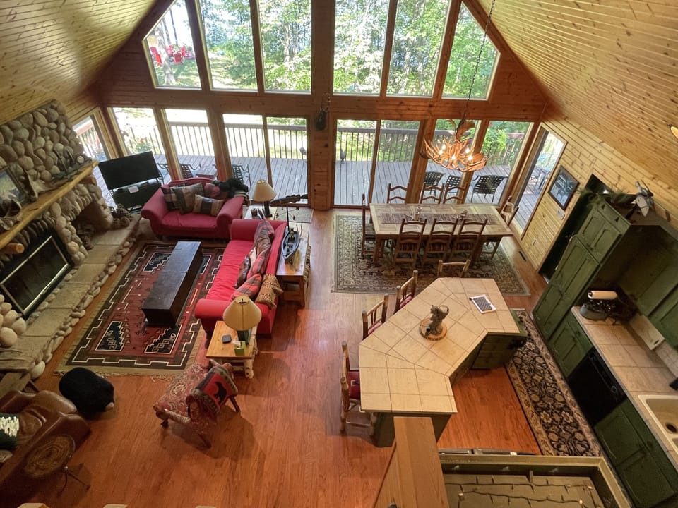 Main floor overlooks lake with tv and fireplace, dining and large kitchen island