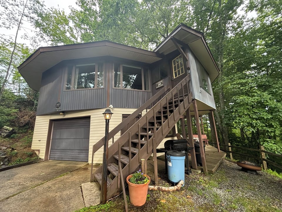 Front . Shows stairs to entry, outside sitting area, gas grill, fire pit