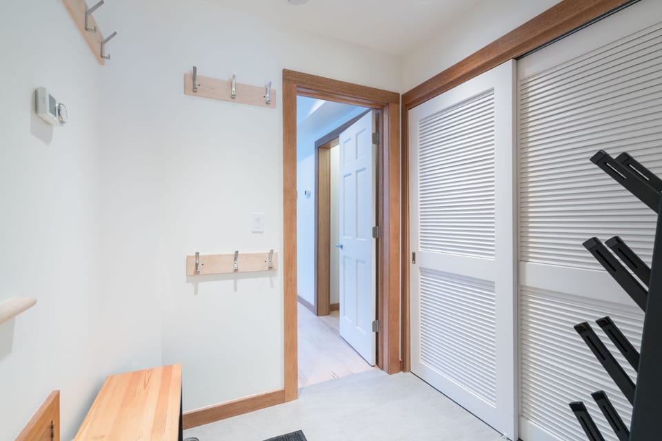 Front entry showing mudroom, laundry, door to guest room & stairs to 2nd level