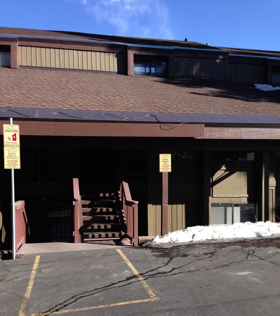 Exterior of building & parking lot. Our unit is down 7 stairs way to the left.