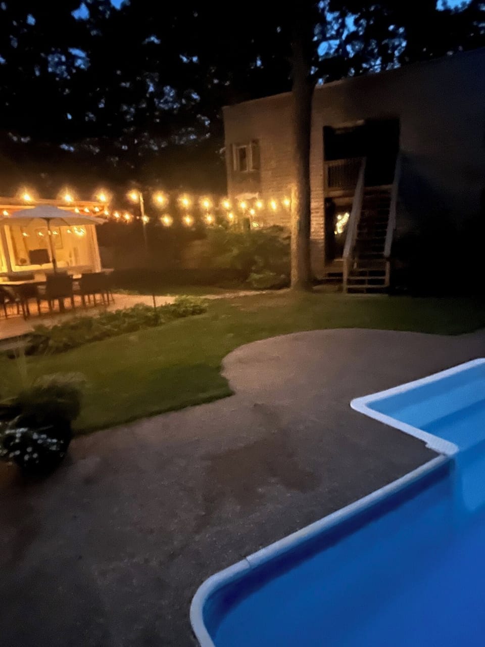 Pool and deck with nighttime lighting.