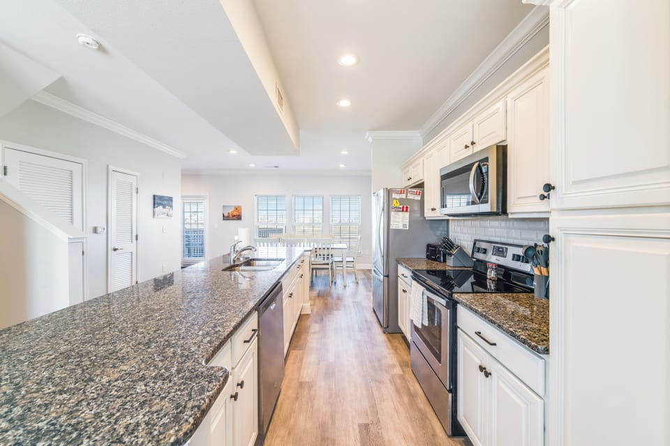 Step into your spacious gourmet kitchen with gleaming granite countertops, crisp white cabinets, and everything you need to create memorable meals.
