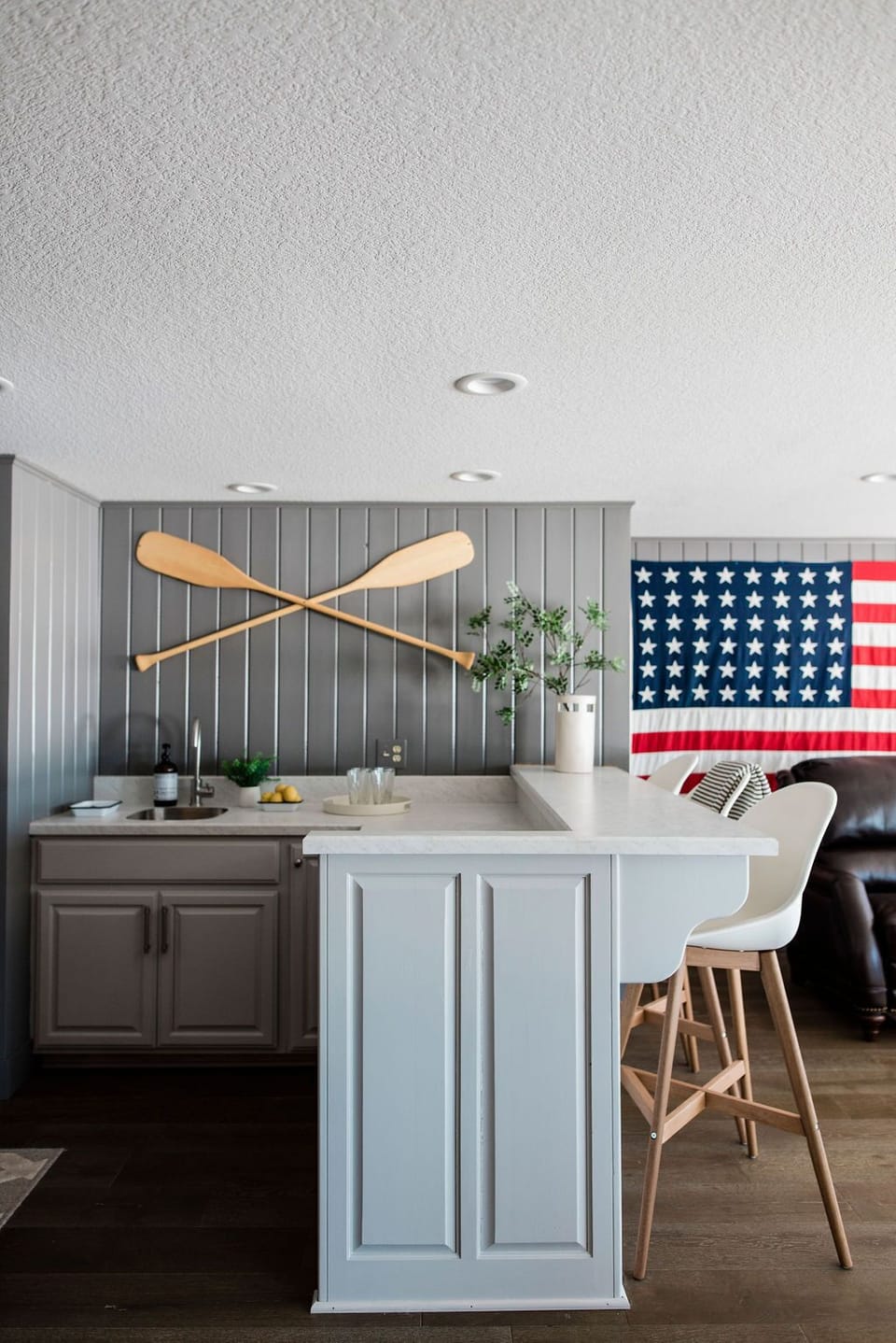 Sink, barstools and storage next to the game table and lounge area.