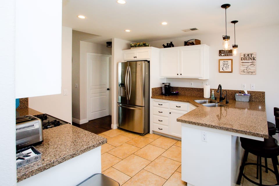 Fully stocked kitchen with granite counters and stainless steel appliances.