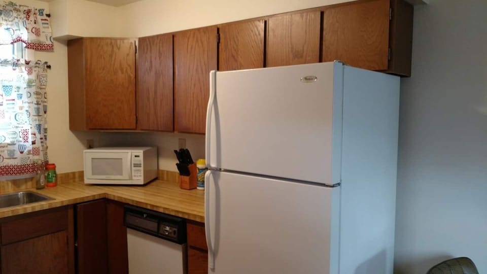 This cozy kitchen includes the essential kitchen gadgets, pots and pans, microwave, and cutlery.