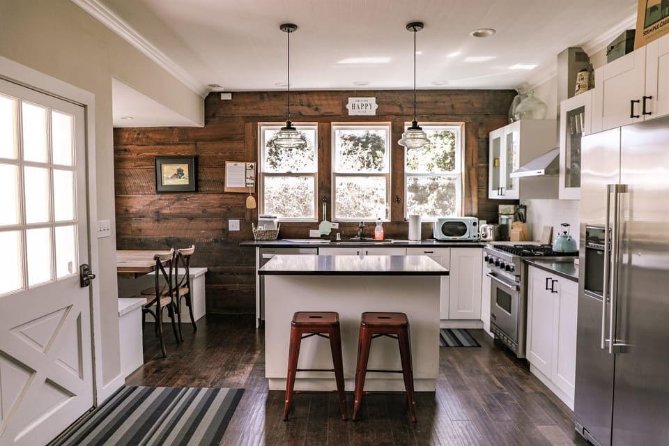 The kitchen has a Viking range, dishwasher, microwave, island with bar seating, and built-in dining table for 6. 