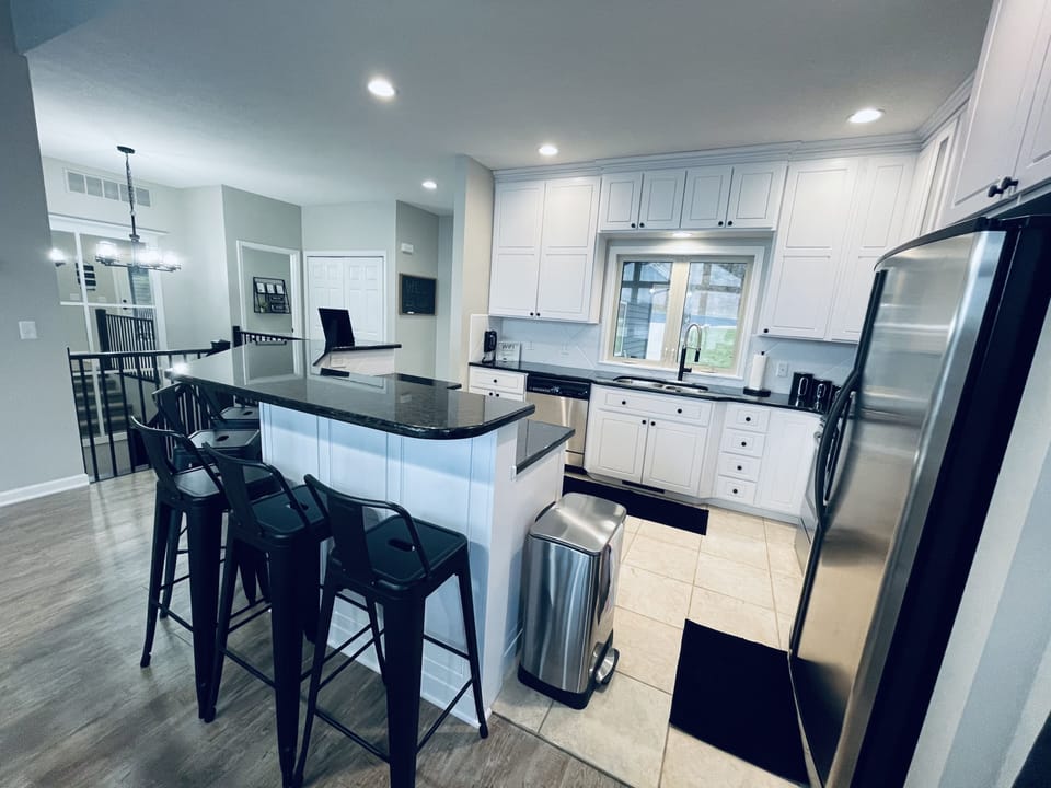 Kitchen features utensils, baking ware, granite counters, & stainless appliances