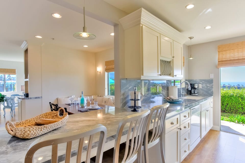 Ocean view kitchen, sliding door to patio/grass/BBQ/seating. Bar seating. 140115