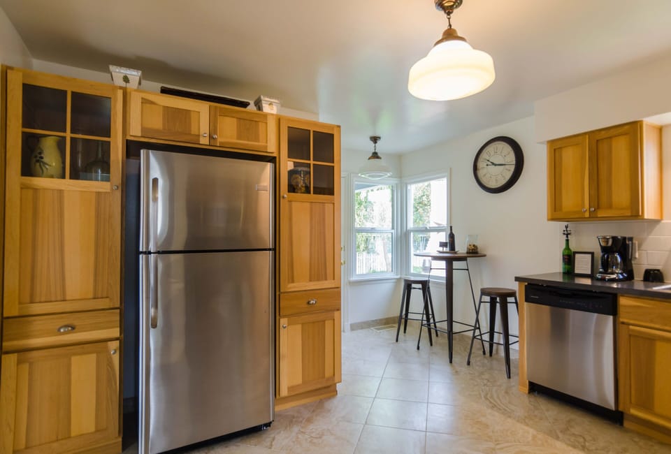 Kitchen stocked with dishes/glasses, pots and pans, coffee maker and toaster.