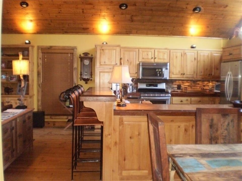 HIGH END CHEF'S KITCHEN WITH FOUR BAR STOOLS AND RECLAIMED WOOD DINING TABLE 