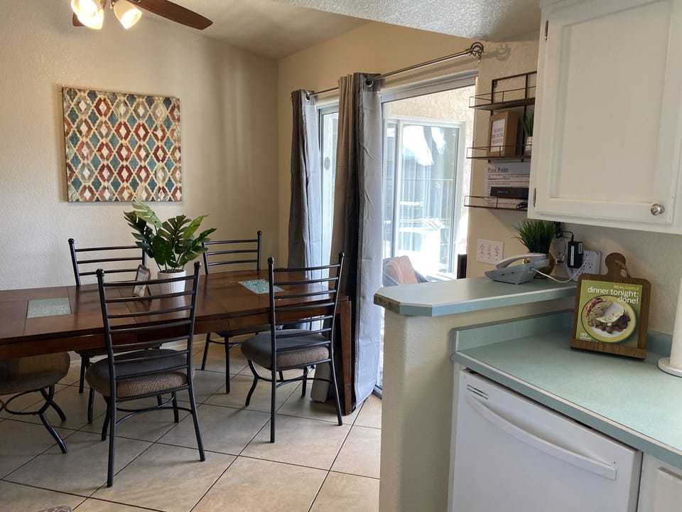 Open kitchen and dining room with patio doors that open up to covered porch/pool