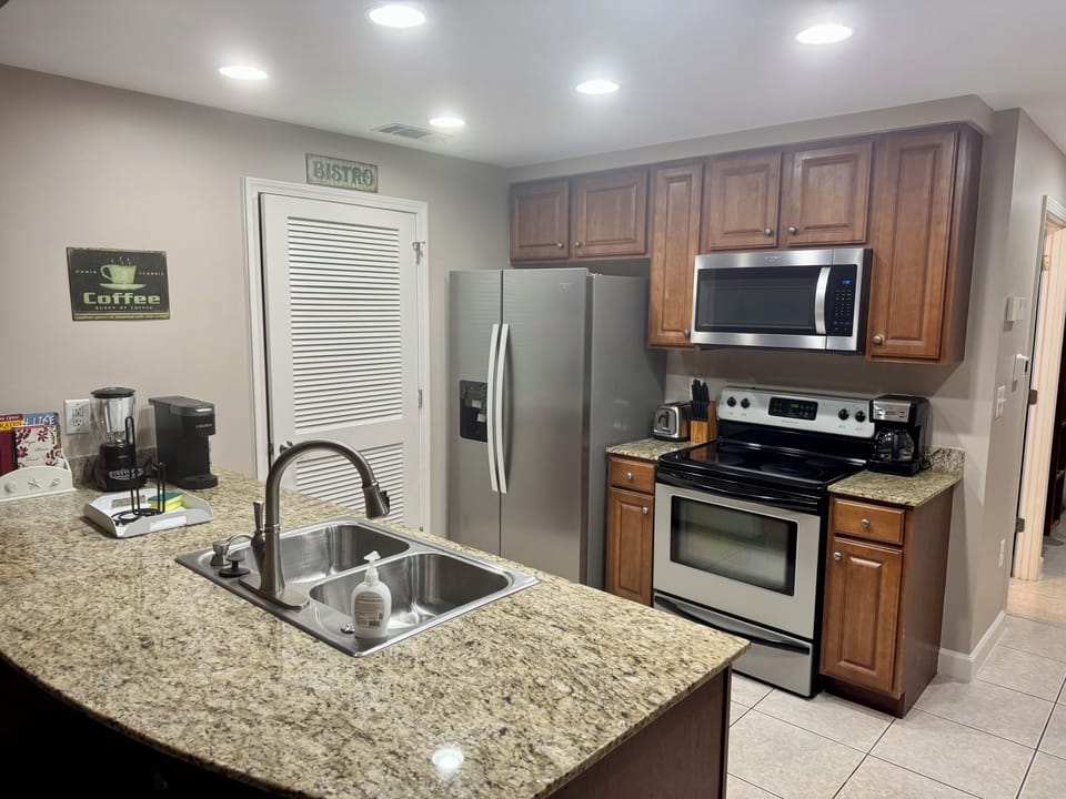 Fully stocked kitchen with granite countertops and laundry room left of fridge. 