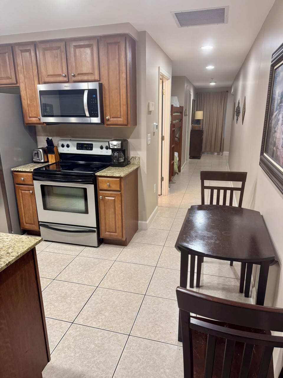 Kitchen with breakfast bar seating and dinette table with chairs. 