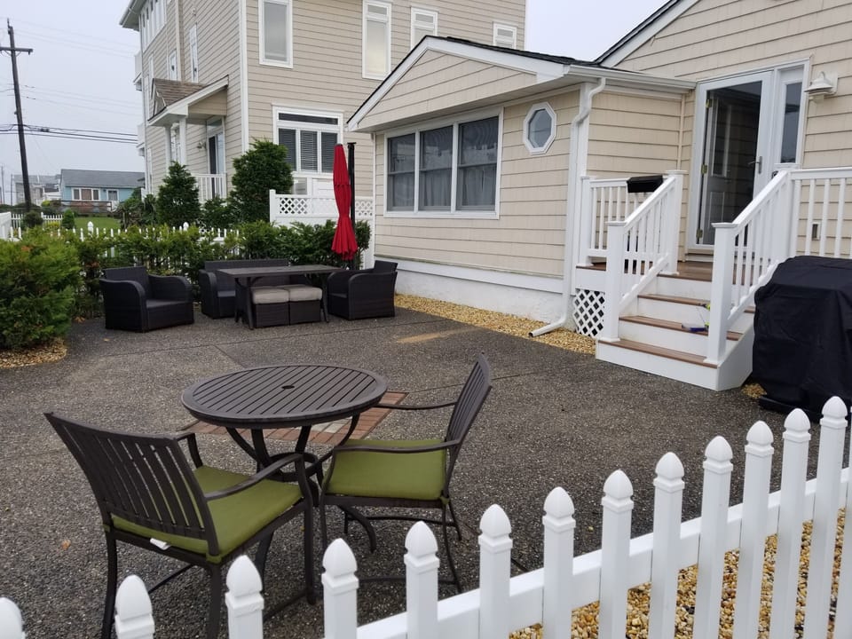 Beautiful fenced in patio with lounge set, eating area, & gas grill.