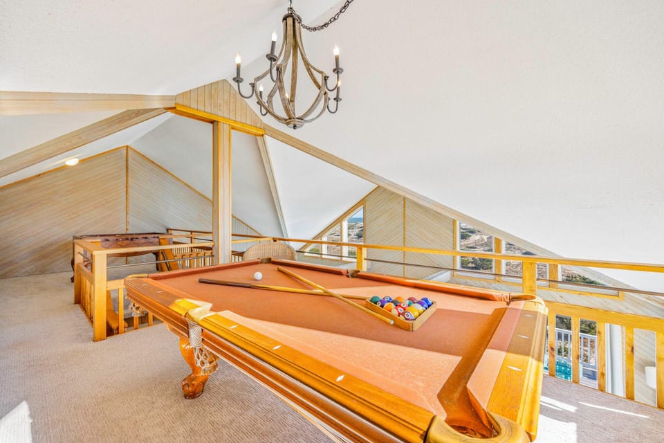 Challenge friends to a game in this stunning loft game room, where soaring ceilings and elegant lighting create the perfect entertainment atmosphere.