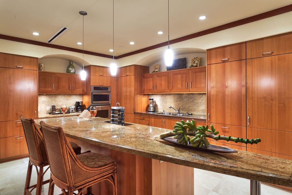 Spacious kitchen with granite counters and travertine floors.