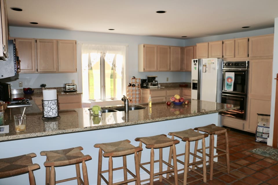 light bright kitchen with seating for 12, granite countertops and ocean view
