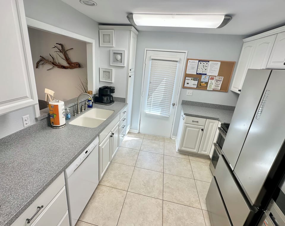 Bright kitchen. Door to outdoor shower and service yard.