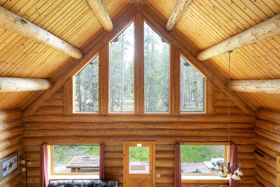 Main bedroom view through cathedral windows to the outdoors, desk & chair.